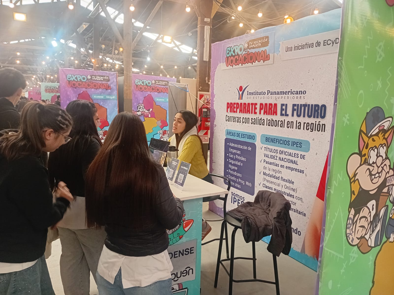 Visitantes consultando en el stand del IPES