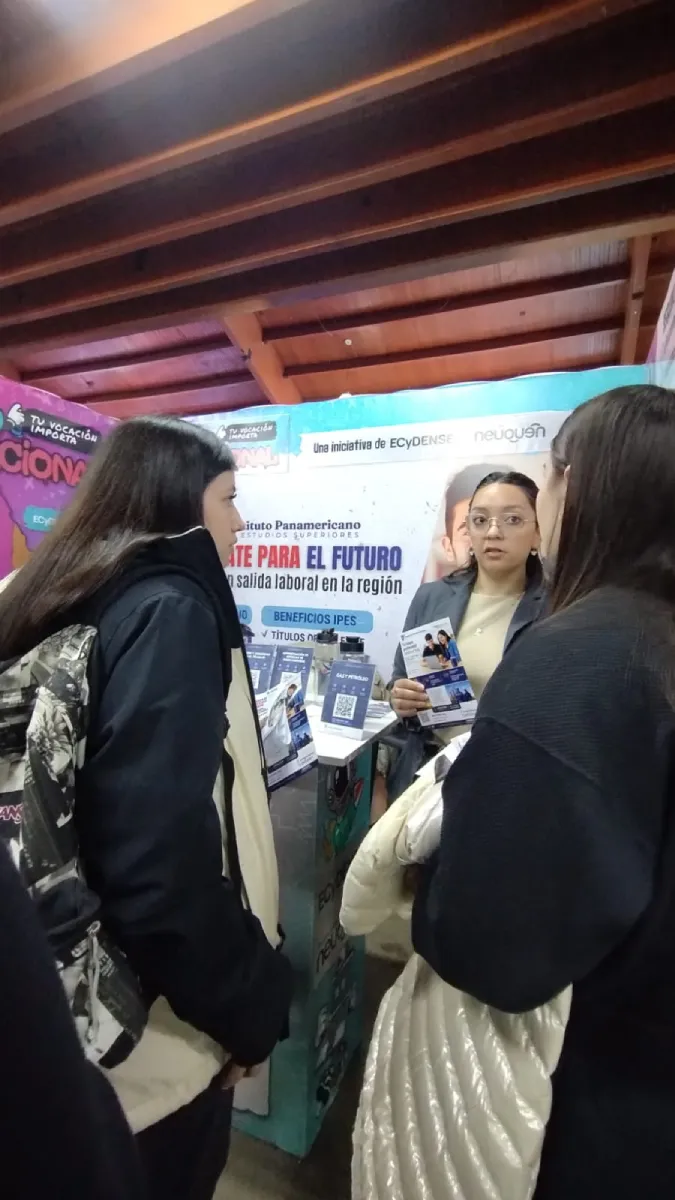 Estudiantes consultando información en el stand del IPES